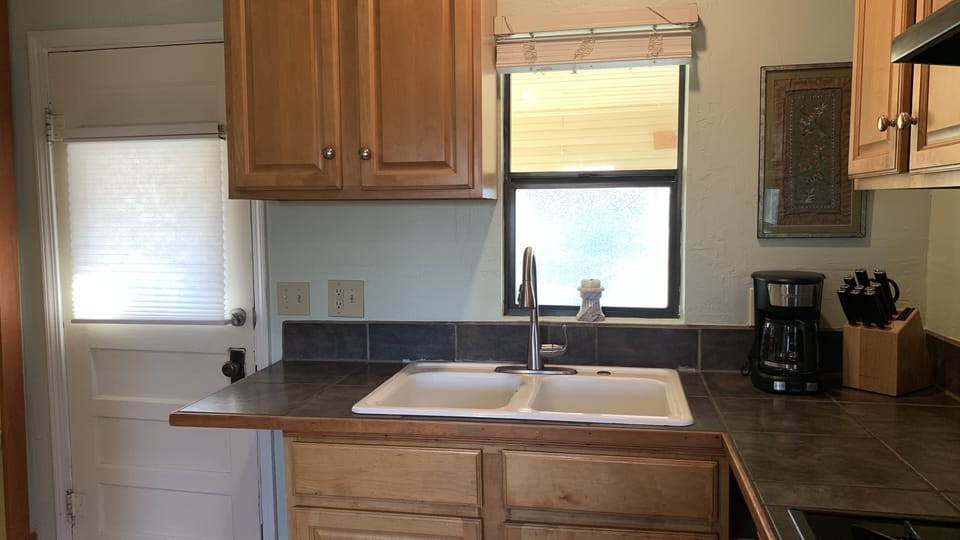 Kitchen has coffee maker, blender, knives, pots, pans, plates
