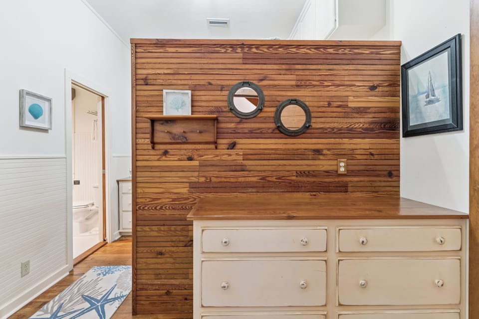 Your cozy nautical bedroom features a stunning wood accent wall and charming coastal decor that creates the perfect seaside retreat.