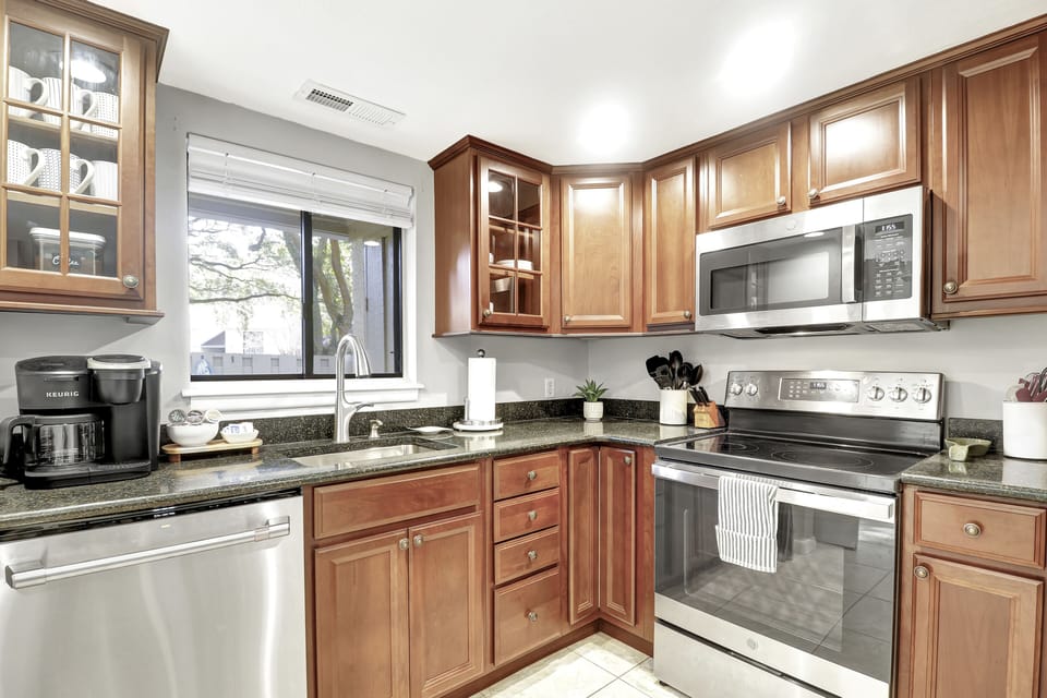 The well-stocked kitchen contains stainless steel pots & pans.