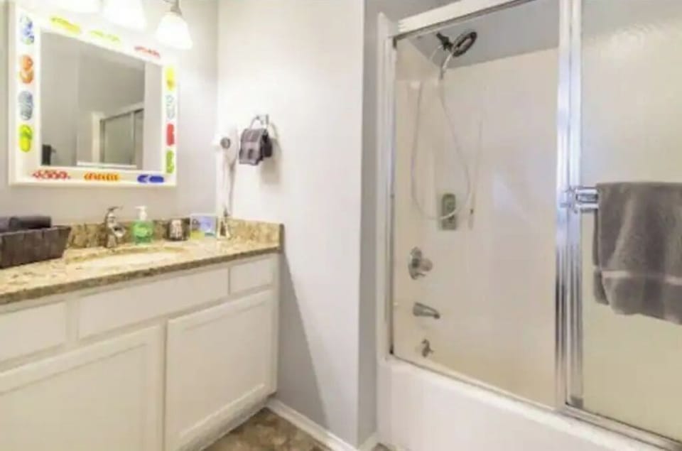 Bathroom off bedroom two with tub, shower and hairdryer.