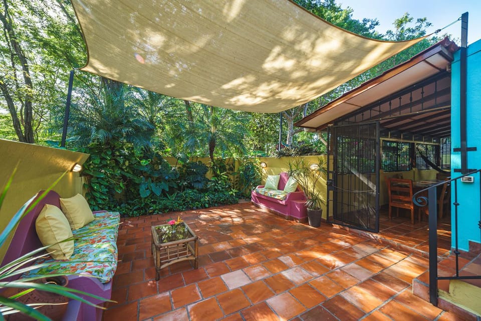 Vibrant courtyard with seating area next to a tropical garden. 