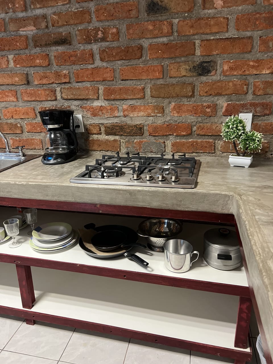 Pans, pots, strainer and plates under the stove.