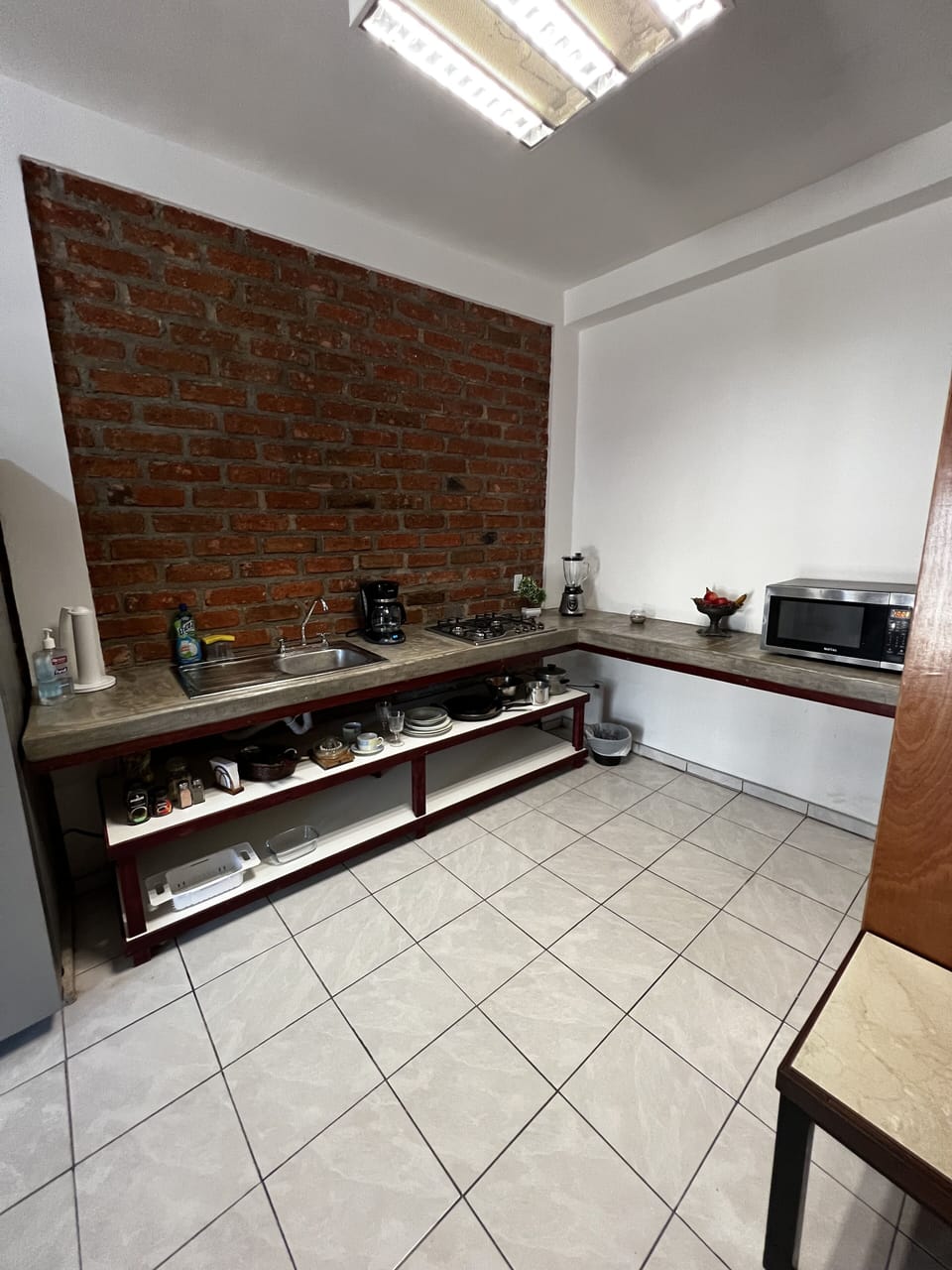 Full kitchen with stove, refrigerator, coffee maker, blender and microwave.