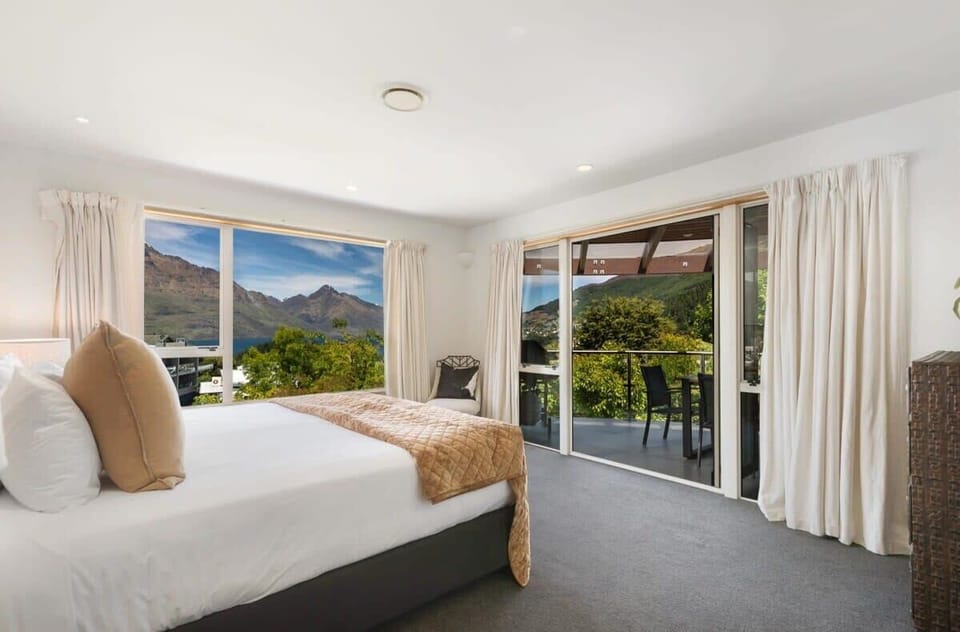 Main Master Bedroom 1: Wake up to stunning mountain vistas and relax on the balcony with fresh air!