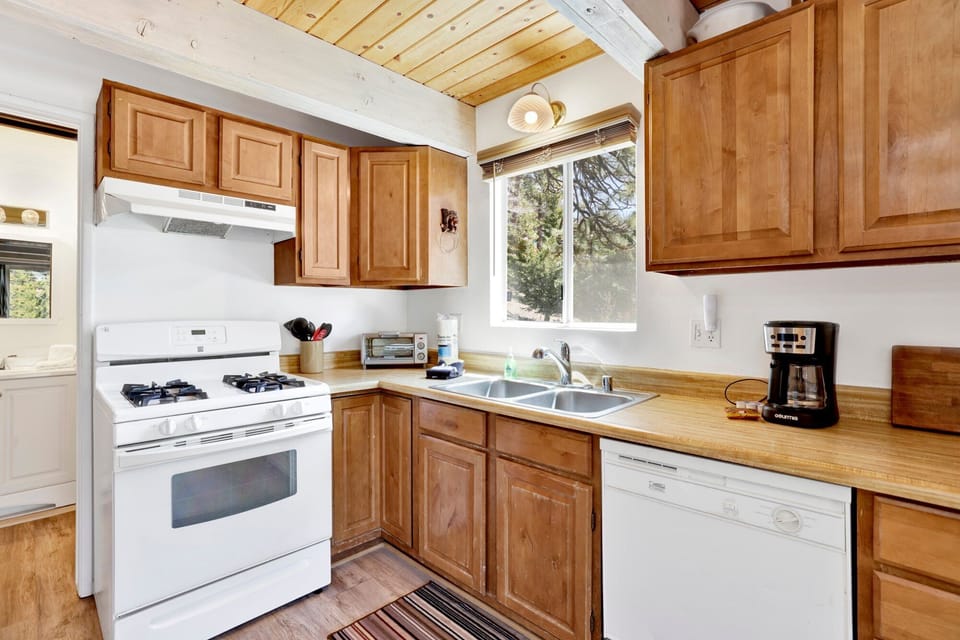 Fully equipped cabin kitchen with ample cabinetry, stove, fridge, microwave, and coffee maker—perfect for cooking meals, morning coffee, and feeling right at home on your stay.