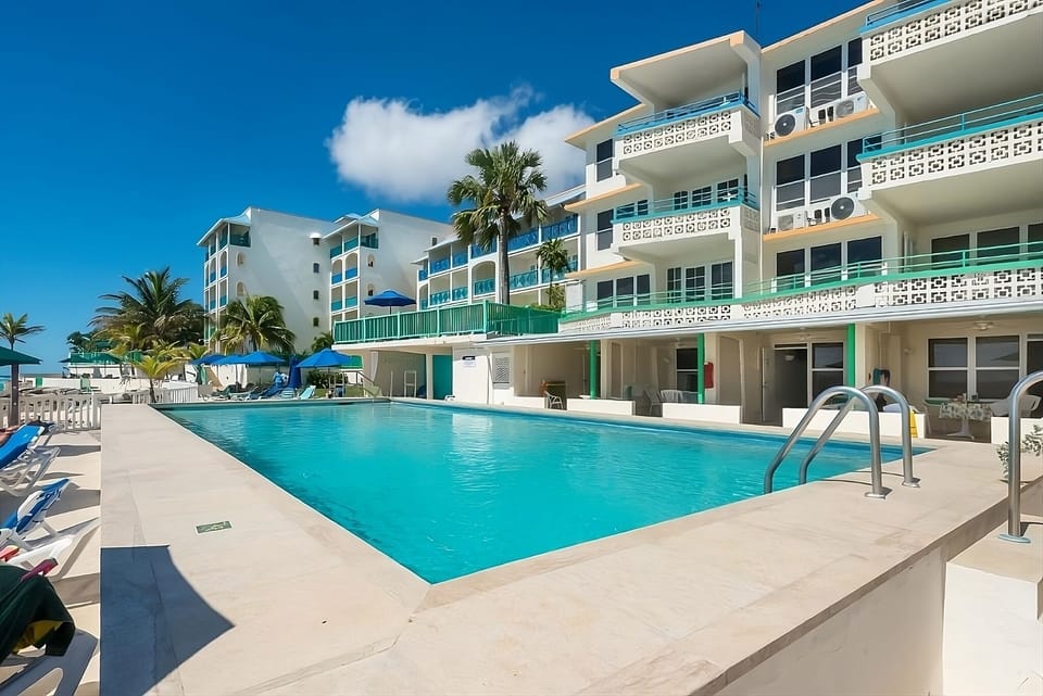 Dive into a sparkling oceanfront pool under sunny skies.