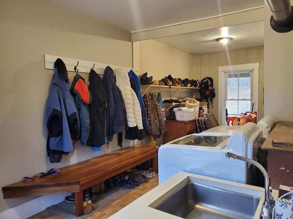 Large mudroom with plenty of hooks & shelves for winter gear. Washer/dryer