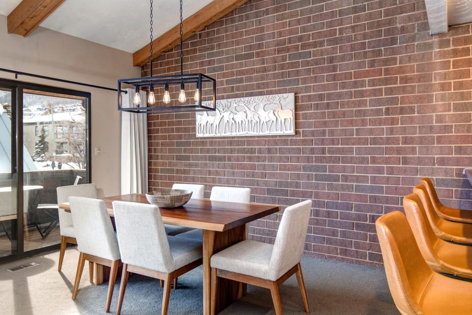 Share meals or board games at your dining table for six beneath modern lighting and brick walls.