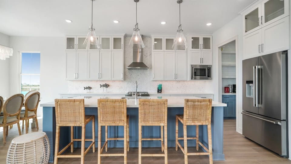 Oversized kitchen island with bar seating for 4 in addition to 8 seats at the dining room table