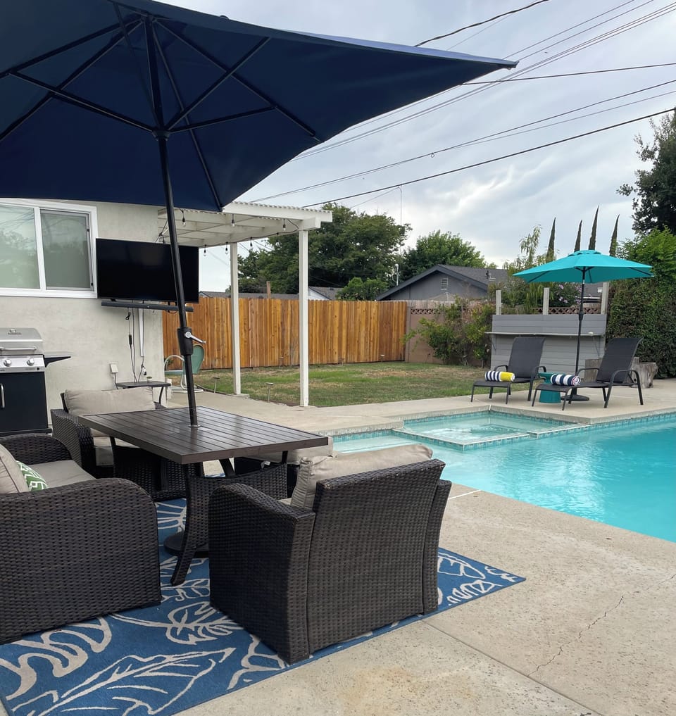 View of patio, grill, outdoor TV, backyard, pool and spa/hot tub/jacuzzi.