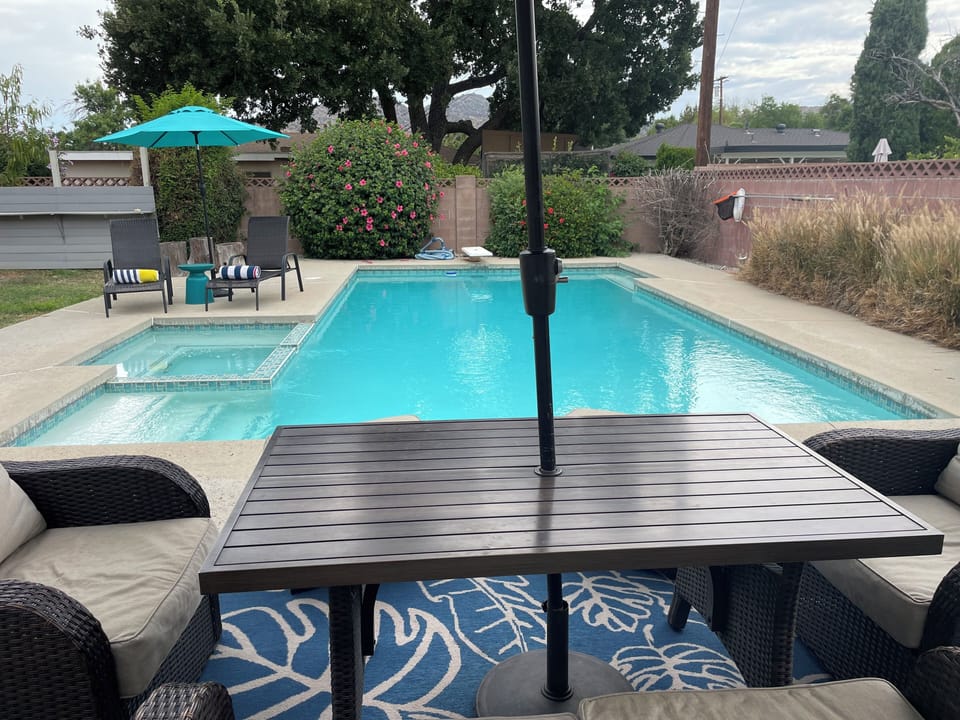 View of pool and spa/hot tub from the outdoor patio.