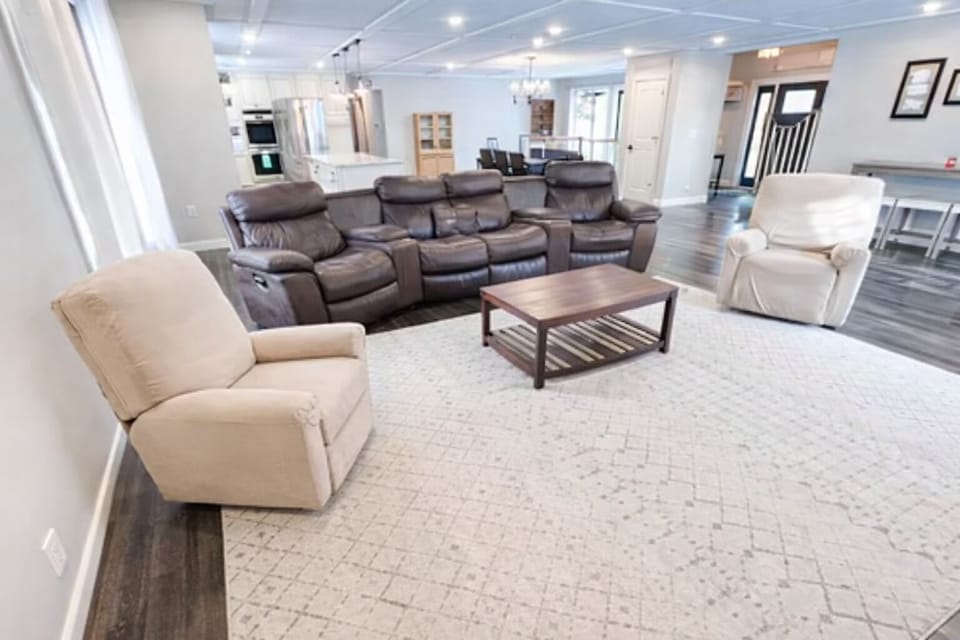 Living room with 6 recliners & Smart TV.