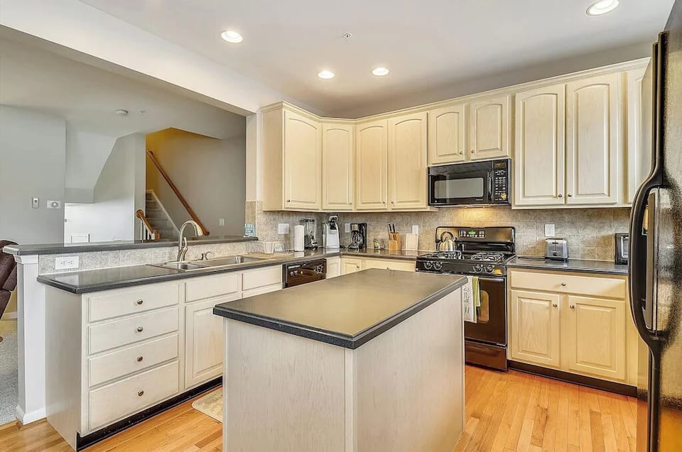 Full size kitchen with hardwood floors, island.