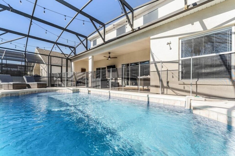 Pool and pool deck with loungers, outdoor sofa dining set, conversation set and smart tv. 