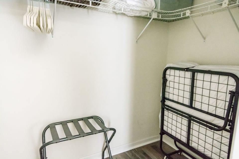 Primary bedroom walk-in closet with twin rollaway bed