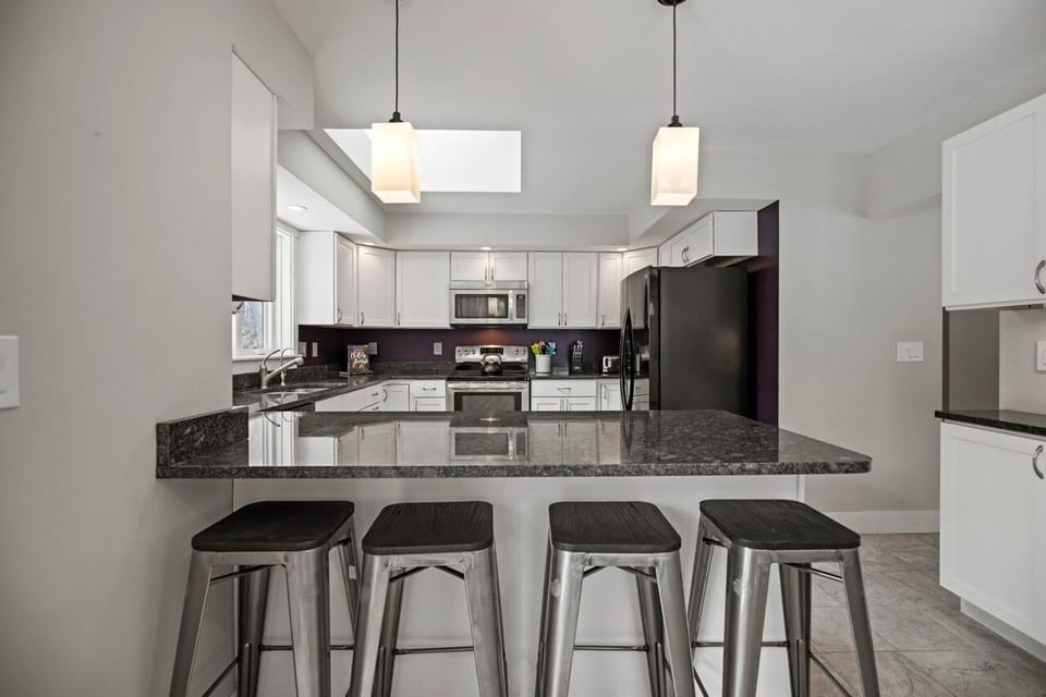 Eat-in breakfast bar with granite countertops and bar stools.