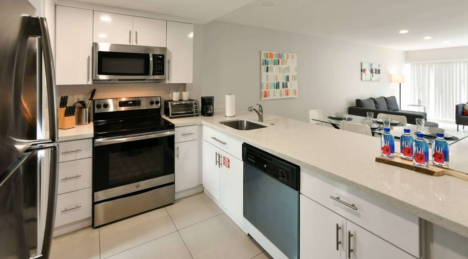 Bright kitchen with stove, sink, dishwasher, and dining view