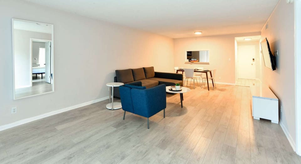 Spacious living room with sofa, chair, dining table, and TV