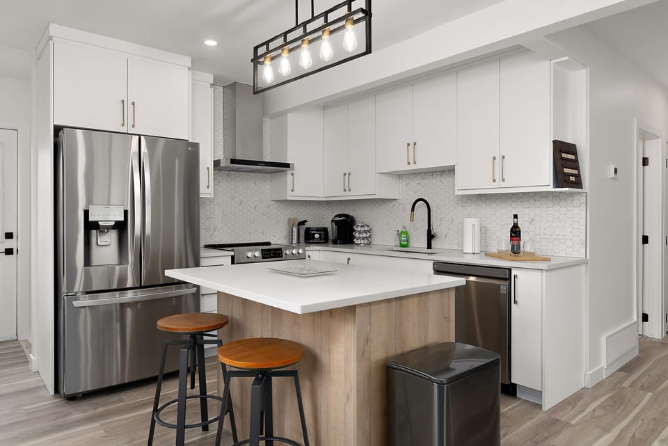 The kitchen features a sleek island with barstools, providing the perfect space.