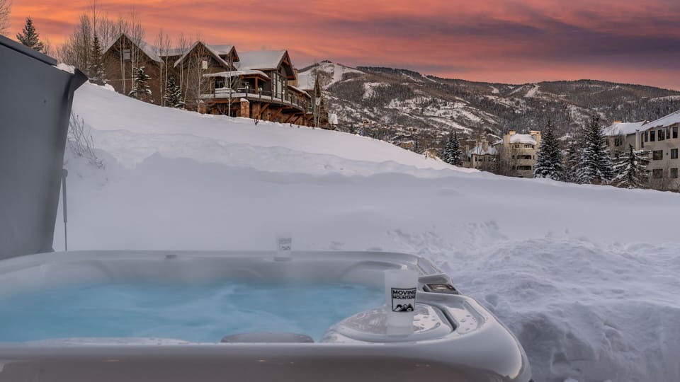 Relax in the hot tub with snowy resort mountain views