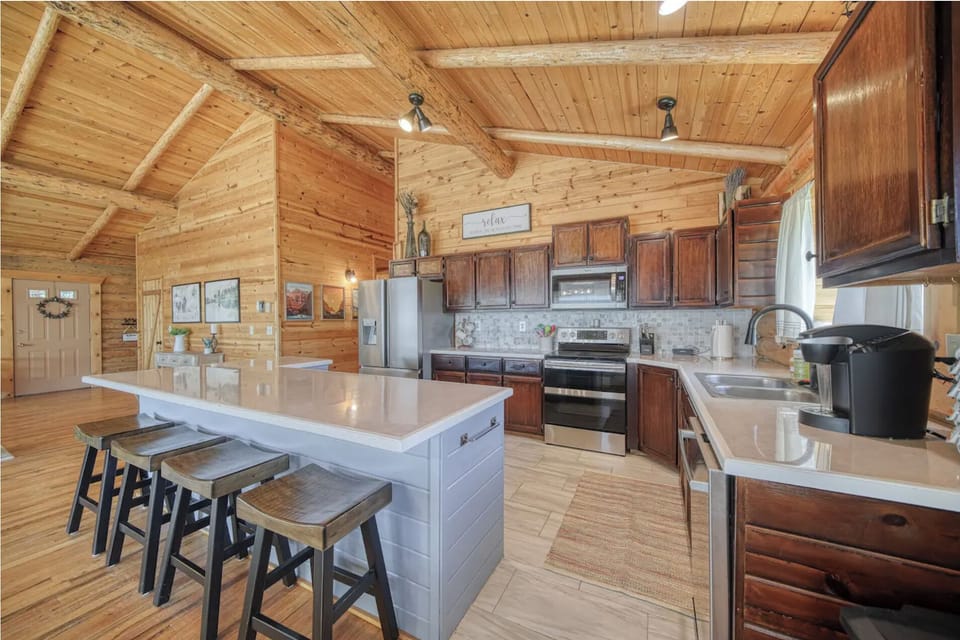 Spacious kitchen with island, modern appliances, and rustic cozy charm.