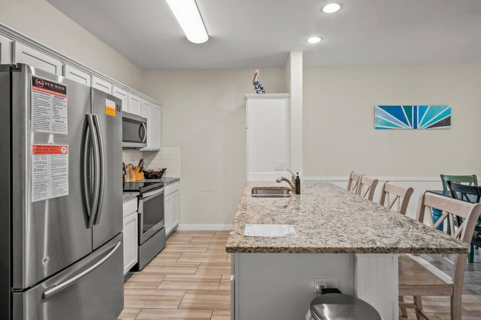 Spacious kitchen with breakfast bar seating and modern appliances.