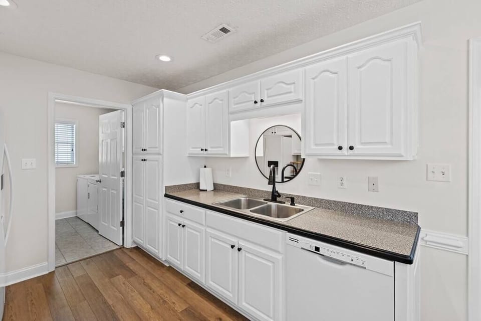 Kitchen with dishwasher going into the laundry room with washer and dryer 