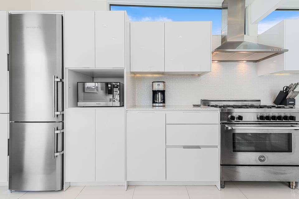 Fully stocked kitchen with stainless appliances & loads of sleek cabinet storage