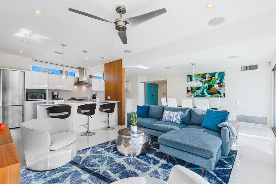 Open concept living area connecting kitchen, dining & lounging areas