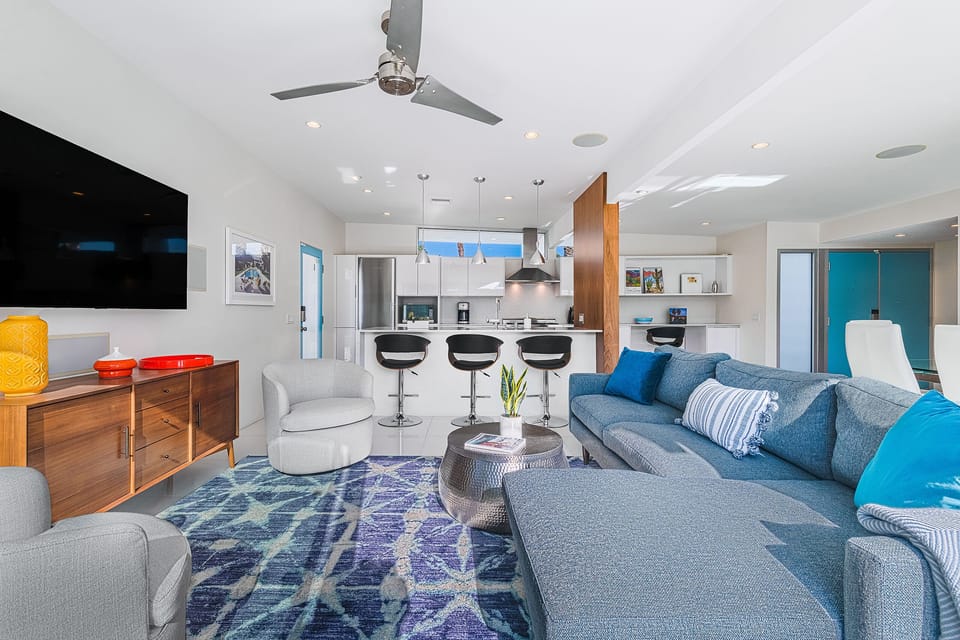 Comfortable lounging area with sectional sofa, club chairs and smart TV