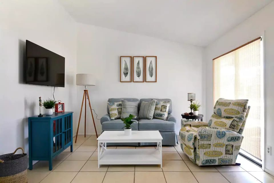 Cozy living room with sofa, recliner and Smart TV.