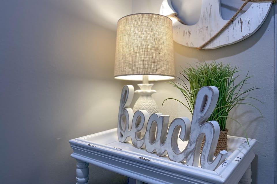 The soft hues of the beach-themed artworks complement the serene and inviting atmosphere of the interior space.