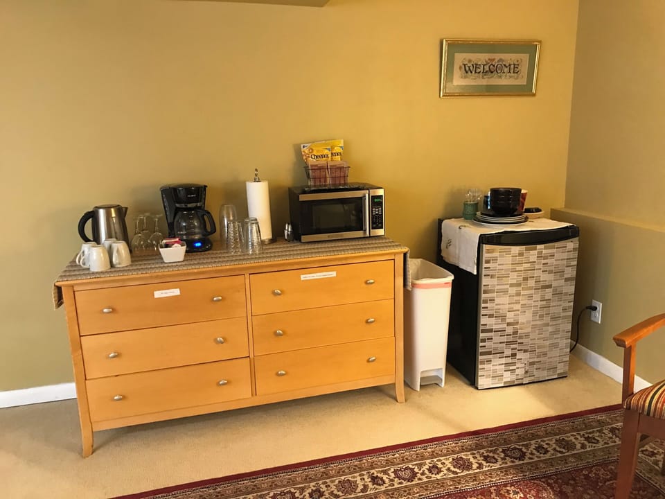 Kitchenette with mini fridge, microwave, coffee maker, electric kettle.
