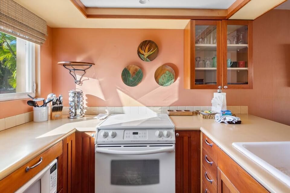 Full size stove/oven in the kitchen with dishes, pots and pans