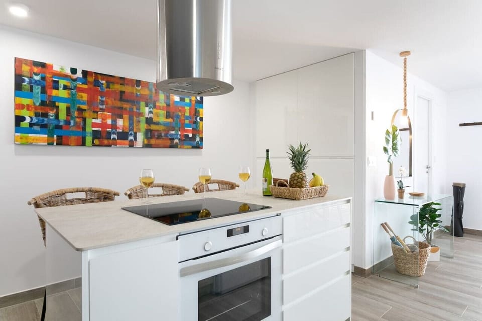 Island counter has 3 high stools, stove top, oven and storage