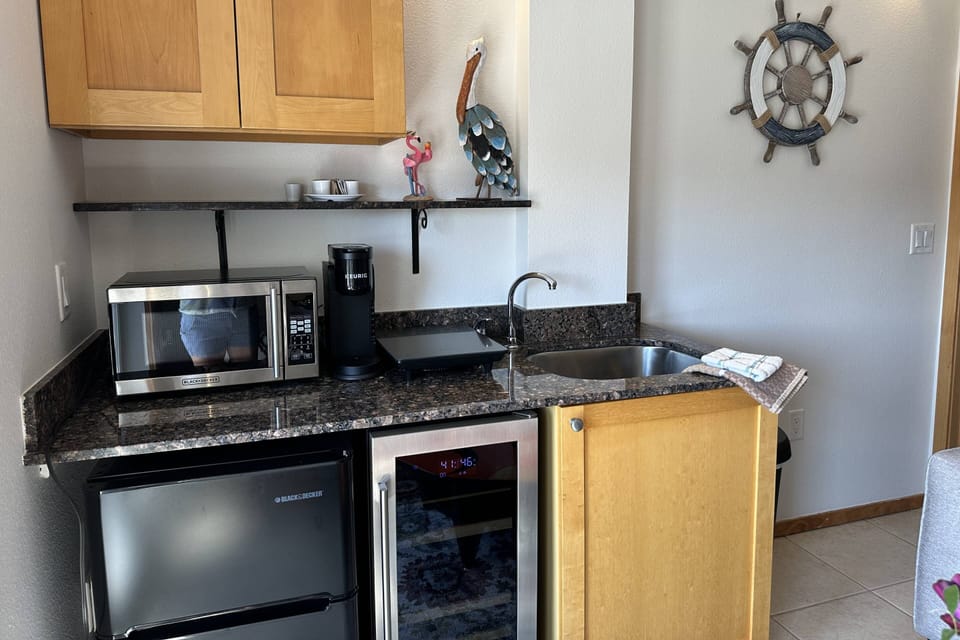 Enjoy the convenience of our kitchenette, featuring a Mini-Fridge, Wine Cooler, Microwave, Cook Top, Coffee Maker, Dishware, Utensils & Air Fryer.