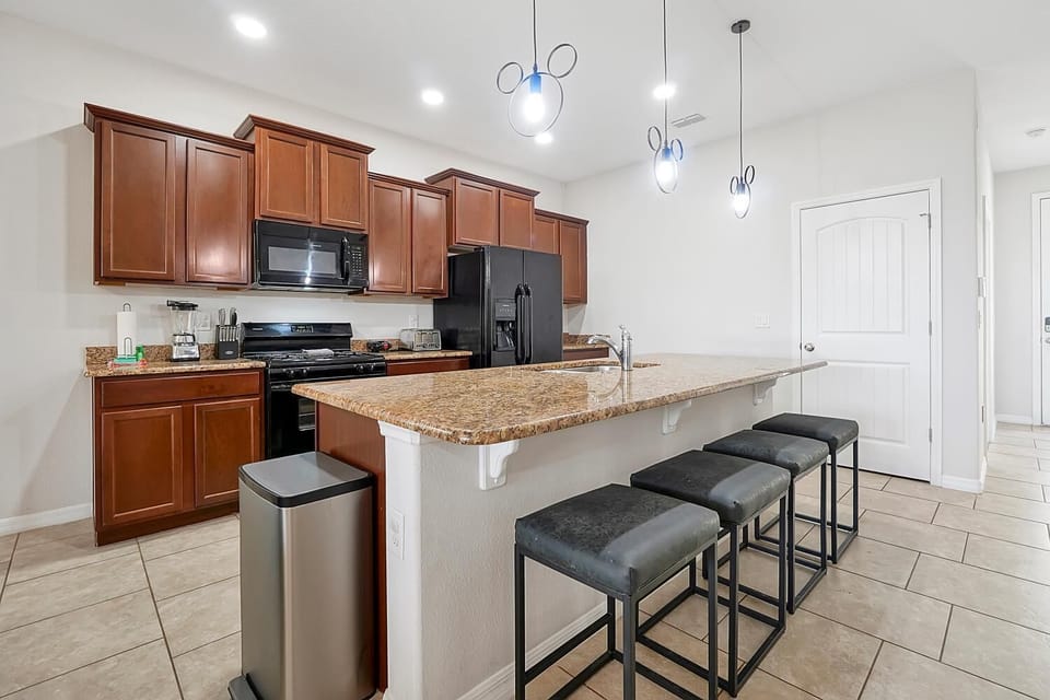 Kitchen breakfast bar with 4 seats. Above the island are Mickey lights