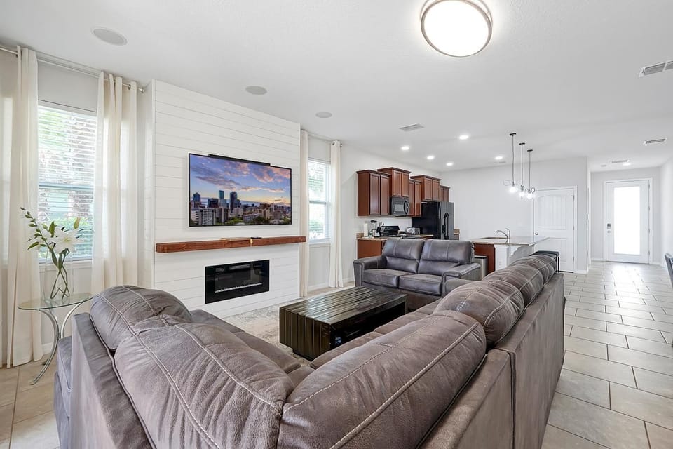 Living room with L-shaped couch and loveseat. Electric fireplace and TV