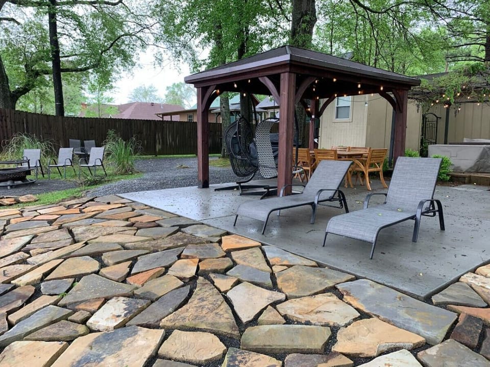 Enjoy outdoor dining and relaxation under a shaded gazebo with twinkling string lights and serene river views.
