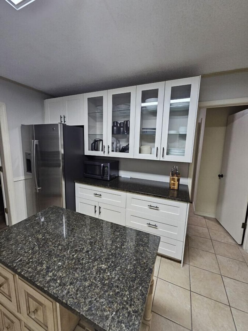 Spacious kitchen with granite island and plenty of prep space for cooking.
