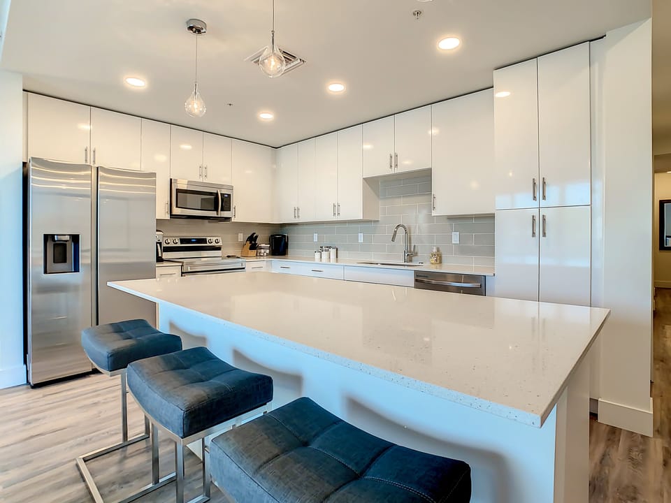 breakfast bar island, abundant cabinets, refrigerator, stove and microwave 