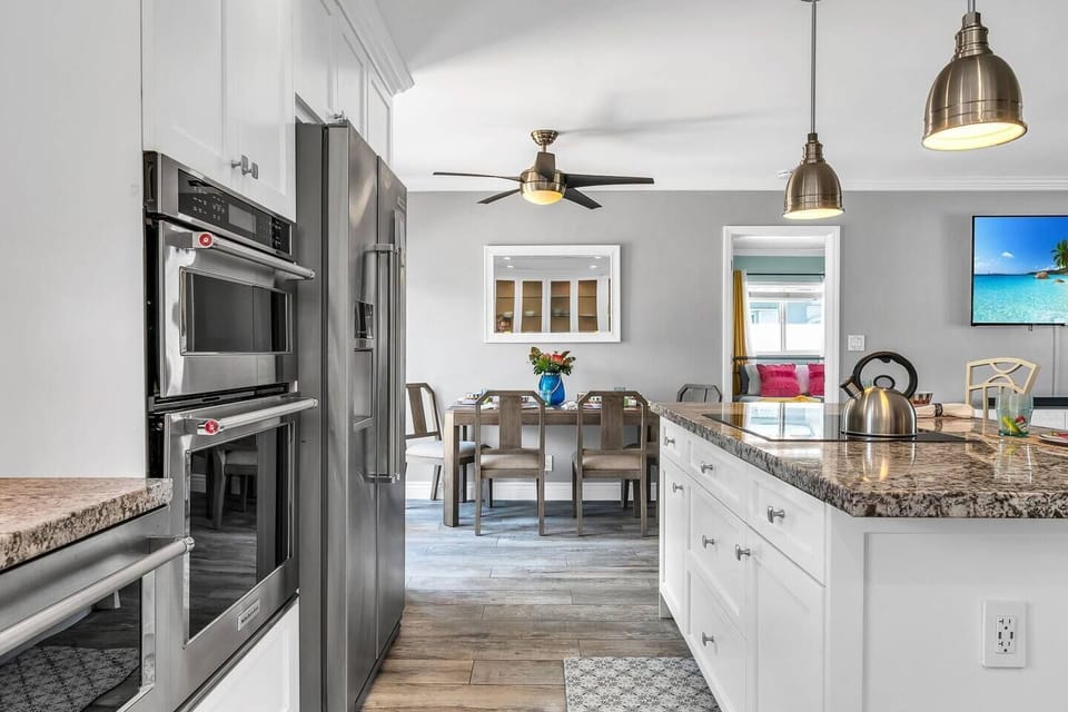 Beautifully updated kitchen with granite tops, shaker cabinetry, induction stove, 2 ovens, toaster oven, Keurig, and drip coffee maker. Service for 8!