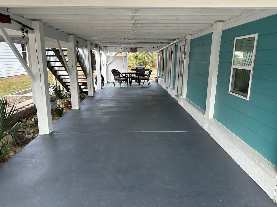 Downstairs patio where there are outdoor games like cornhole, paddle ball, spikeball.