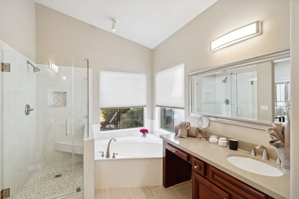 primary bathroom attached to bedroom. Soaking tub and separate shower. Pool view