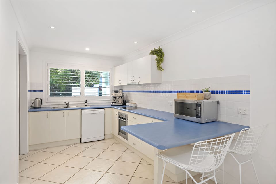 Kitchen with oven, stove top, espresso coffee machine, microwave and dishwasher