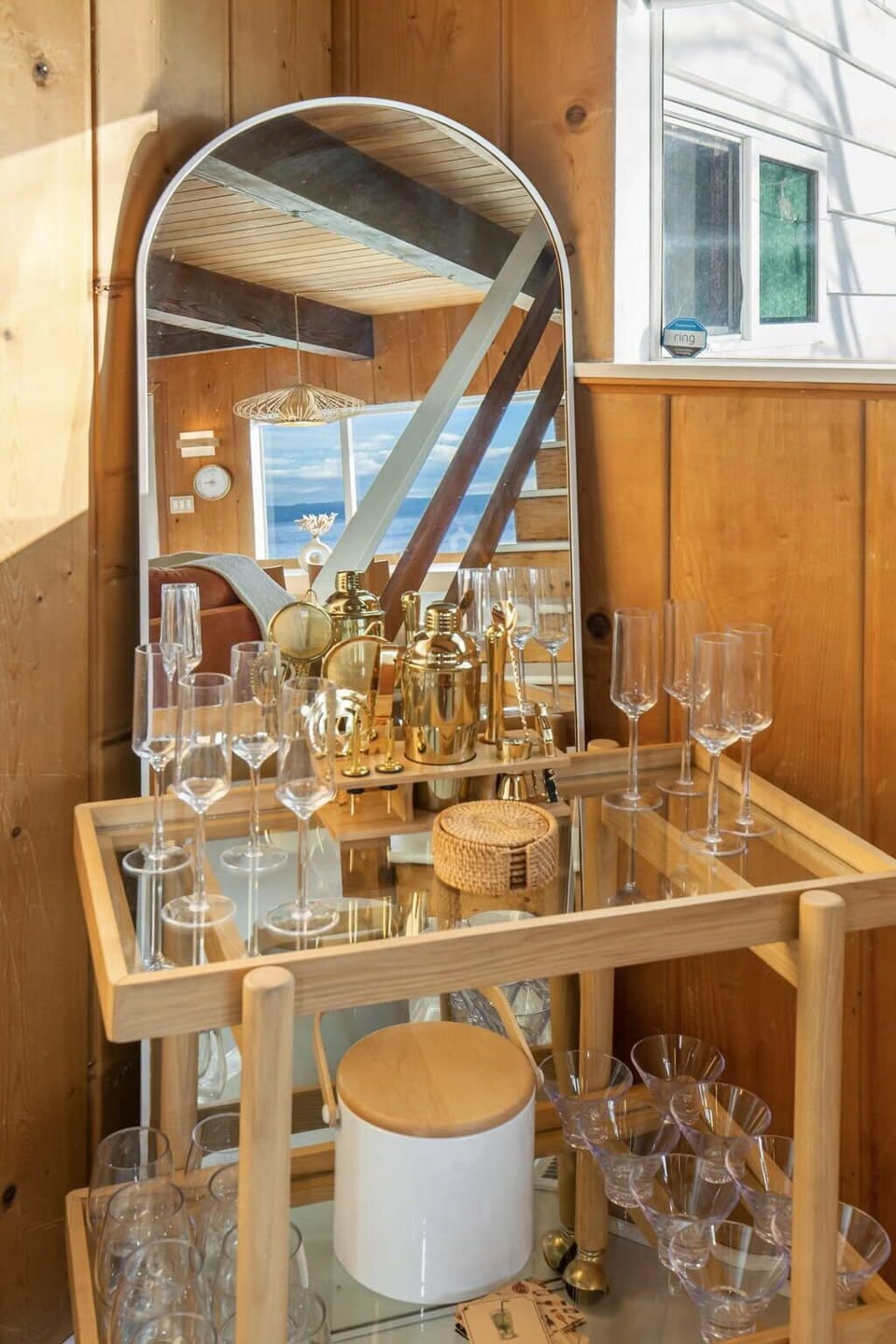 The bar cart holds an ice bucket, wine/martini glasses, & home bartender kit.