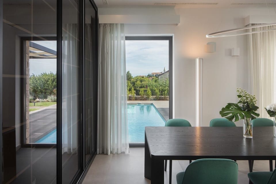 Dining table with chairs and direct access to the outdoor terrace with a private heated pool in the Croatia luxurious villa Art Zen in Istria