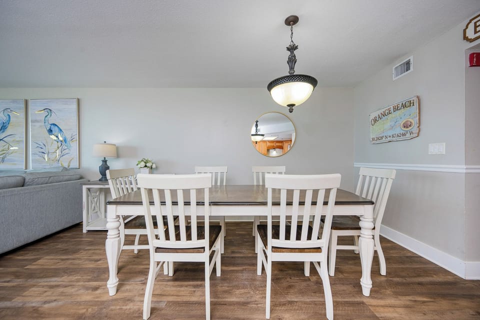 Gather around the wooden table in the dining area where soft light creates a cozy atmosphere for your meals