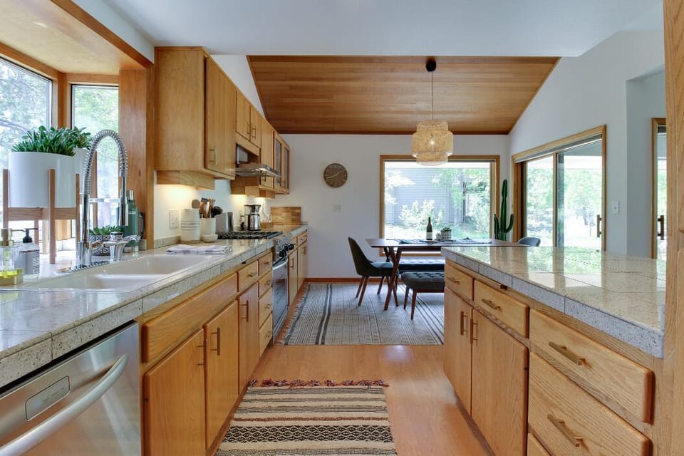 The kitchen features stainless steel appliances and a complete array of cookware