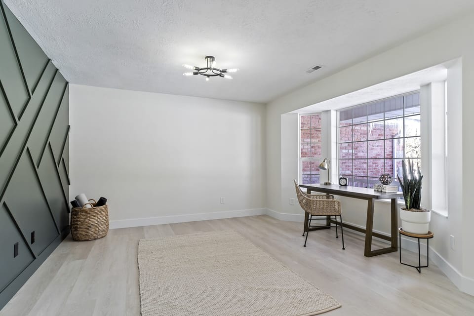 Office/ gym equipped with yoga mats and a desk 